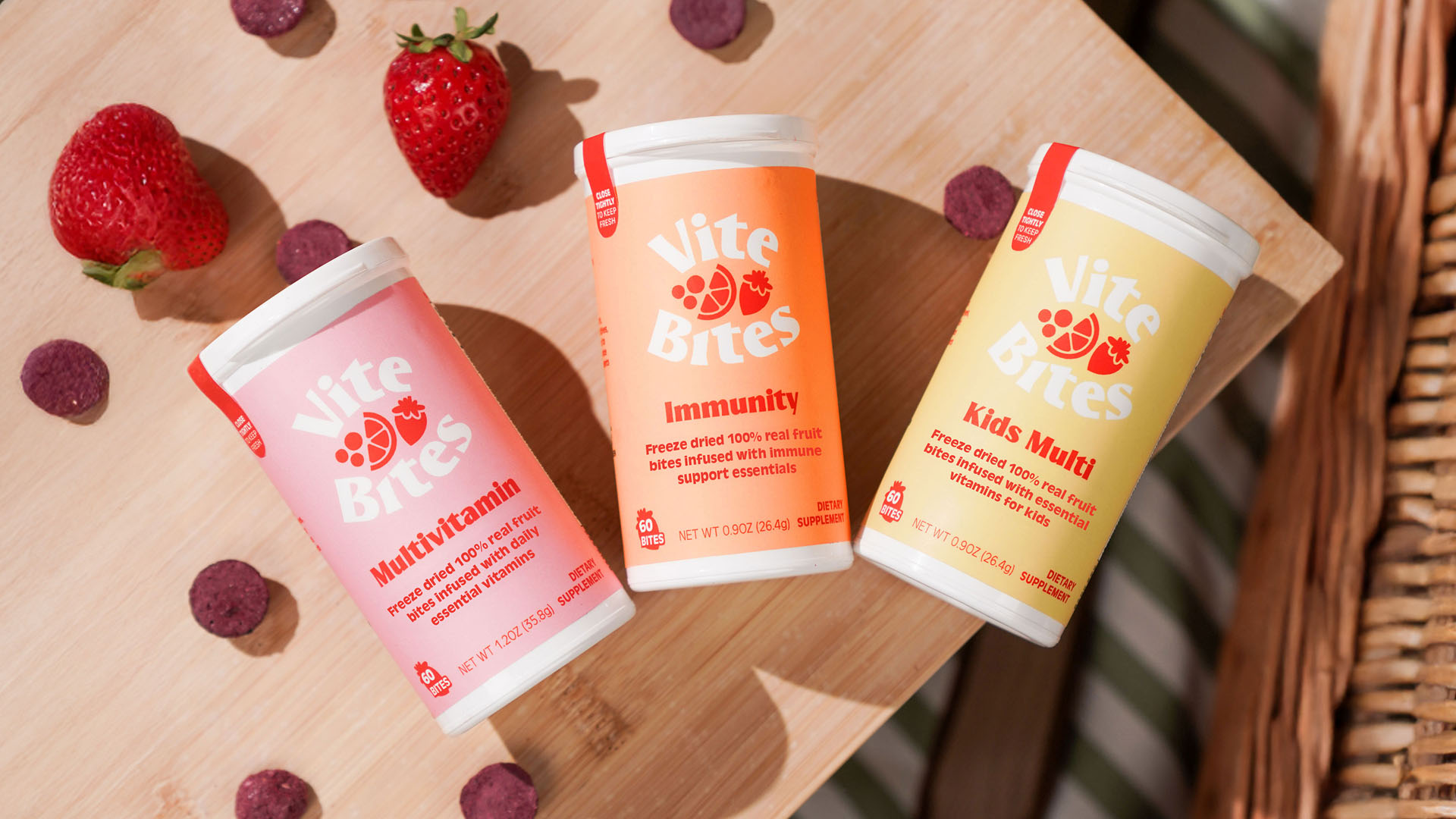 Vite Bites Product Photography Vite Bites supplement containers arranged on a wooden surface with fruit