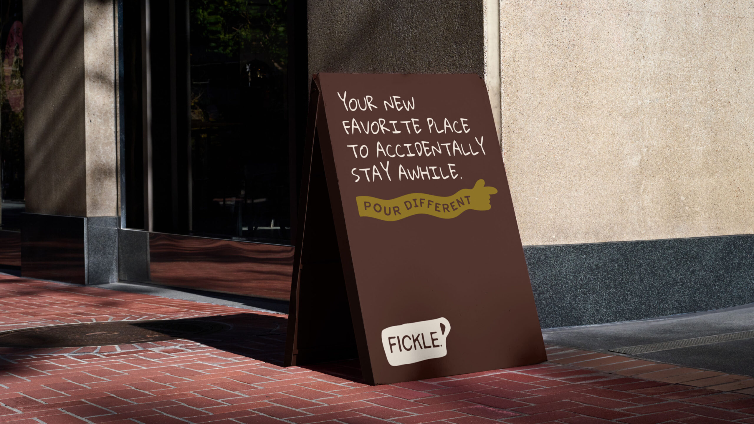 Fickle. Coffee A-frame sign on a sidewalk reading “Your new favorite place to accidentally stay awhile”