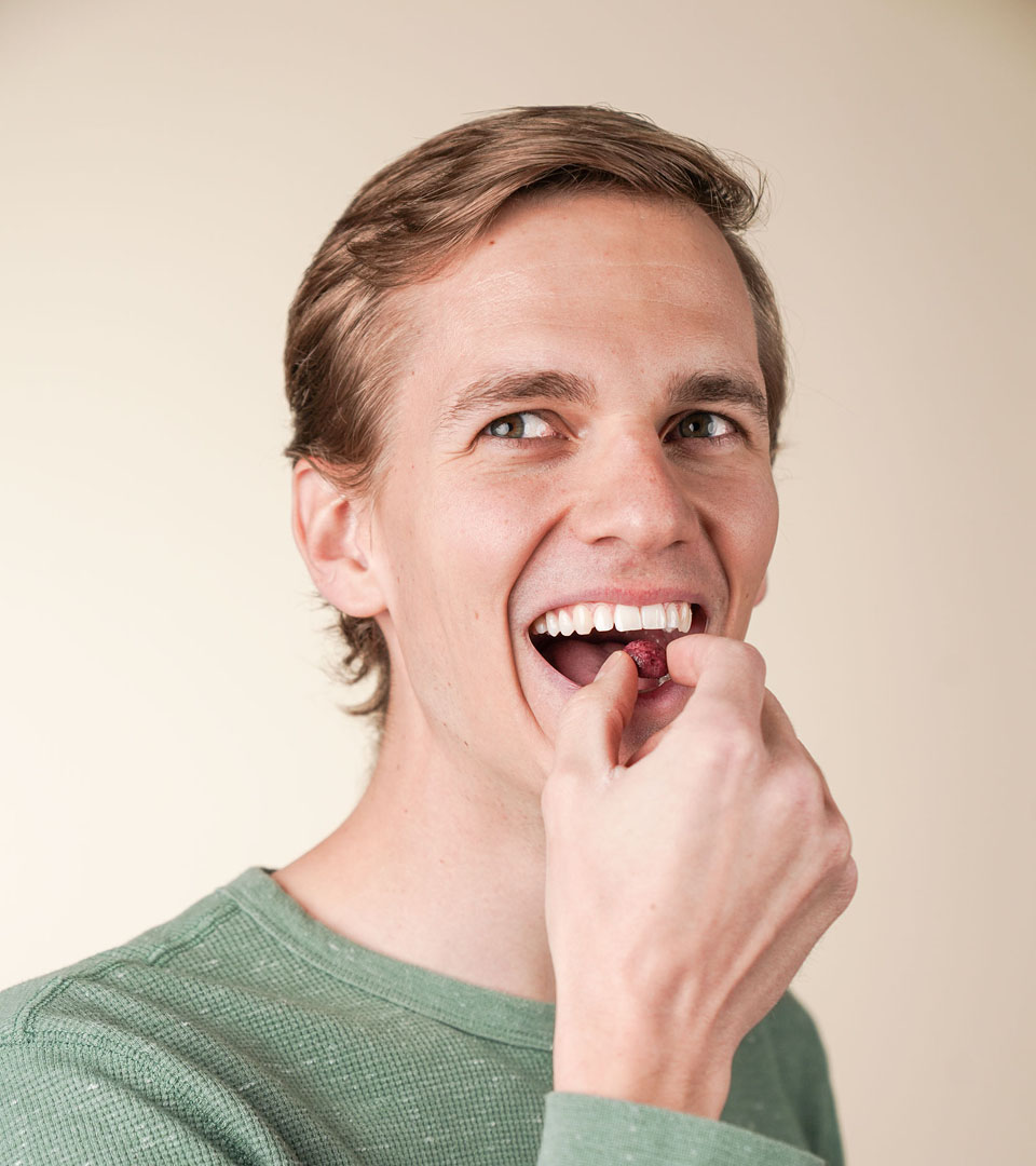 ViteBites Product in Use Person eating a single ViteBites supplement against a neutral background